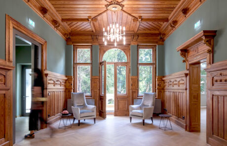 Elegantes Foyer in traditioneller Holzarchitektur mit modernen Sitzmöbeln und Beleuchtung