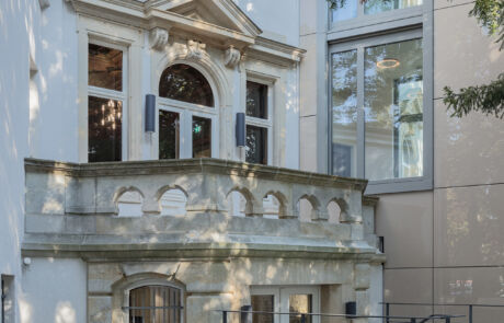 Restaurierte historische Fassade mit modernem Anbau und Sitzbereich im Garten